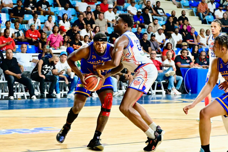 Luismal Ferreiras, del club Mauricio Báez, es fuertemente defendido por Jordan Geronimo, de San Lázaro.