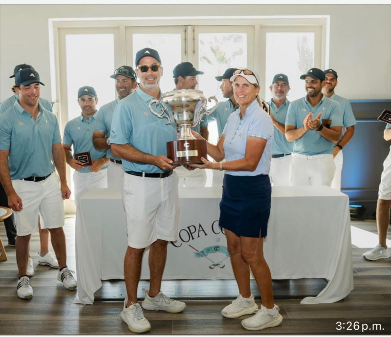 Brenda Corrie entrega la Copa de Campeón a Manuel Luna.