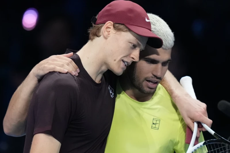 Jannik Sinner, a la izquierda, y Carlos Alcaraz se abrazan después del juego final de las Finales del ATP, en Turín, Italia, el 16 de noviembre de 2025.