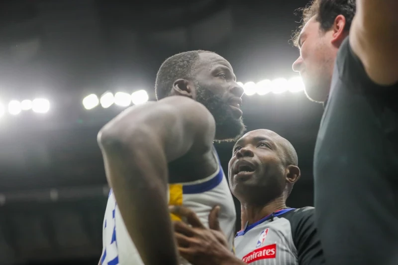 El alero de los Warriors Draymond Green es sostenido por el árbitro Courtney Kirkland durante una confrontación con un aficionado de los Pelicans.