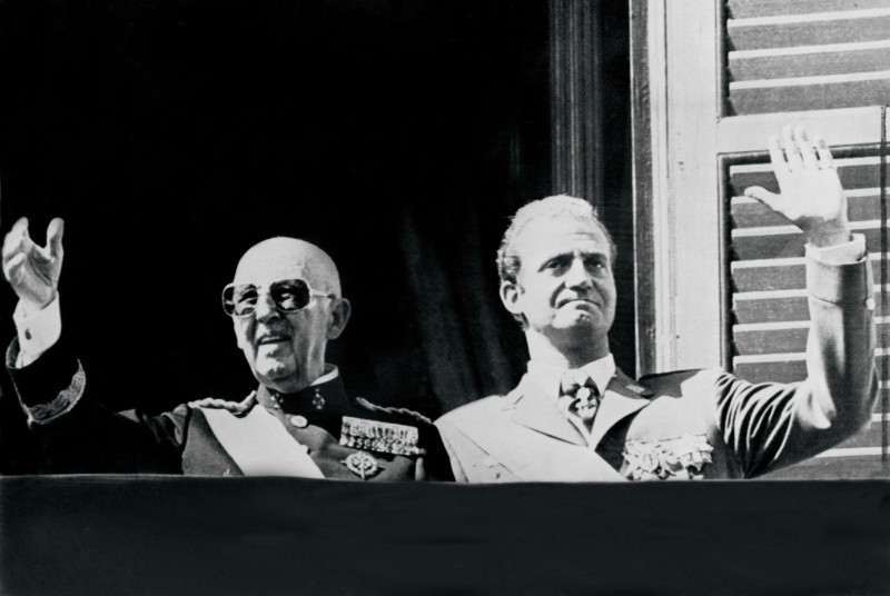 El presidente español, el general Francisco Franco (izq.), y el príncipe Juan Carlos saludan a la multitud en Madrid en octubre de 1975.