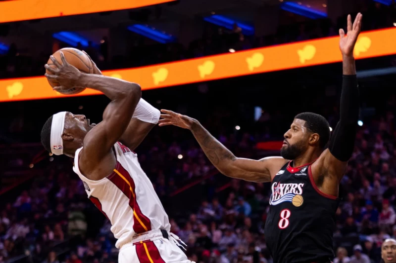 Bam Adebayo, del Heat, a la izquierda, busca lanzar contra Paul George, de los 76ers de Filadelfia, a la derecha, durante la primera mitad de un juego de la NBA.