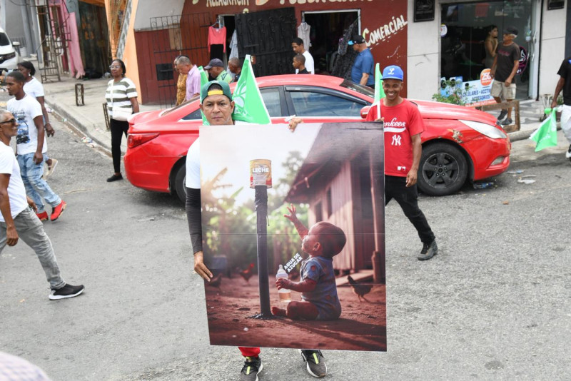 Manifestante muestra pancarta en la marcha dirigida por el partido de la Fuerza del Pueblo, el 30 de noviembre 2025.