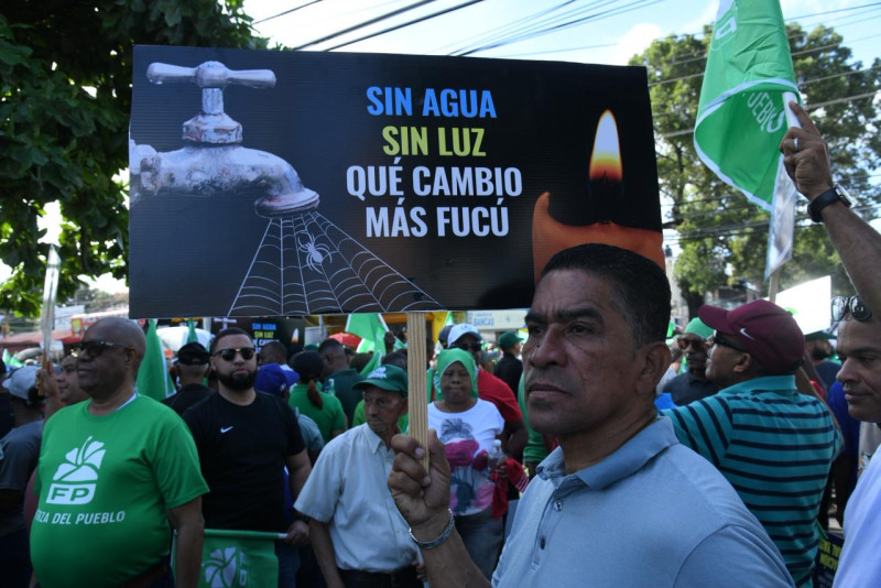 "Sin agua sin luz, qué cambio más fucú", dice una de las pancartas en la marcha dirigida por el partido Fuerza del Pueblo, el 30 de noviembre 2025.