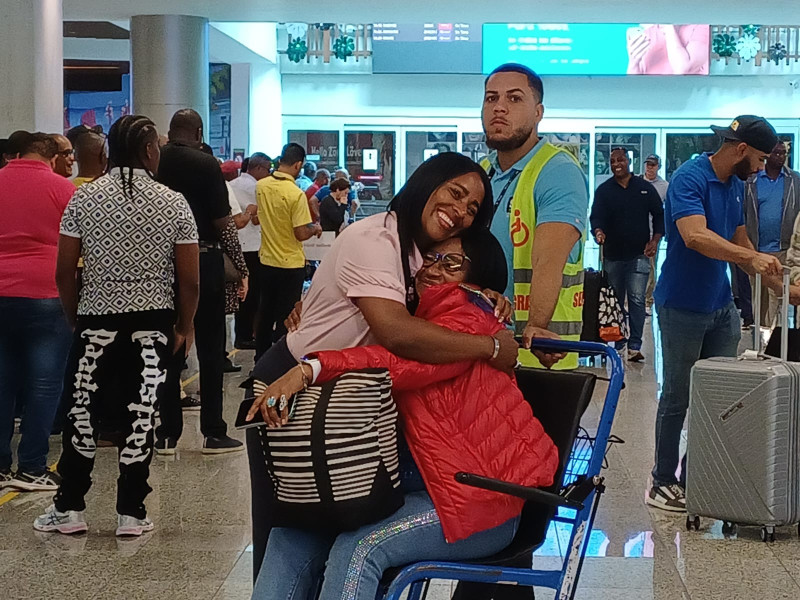 Dos mujeres se funden en un abrazo dentro del Aeropuerto Internacional Las Américas.
