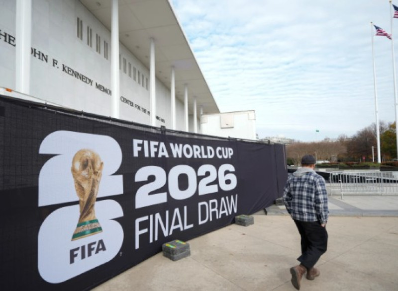 Un hombre pasa junto a un cartel antes del sorteo final de la Copa Mundial de Fútbol de 2026 en el Kennedy Center de Washington.