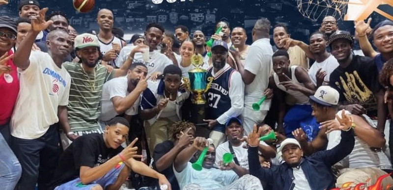 Fidel Castillo, presidente del club Todos Estrellas de Consuelo, presenta la Copa BanReservas, que ganó ante Miramar, y celebra con los jugadores y seguidores.