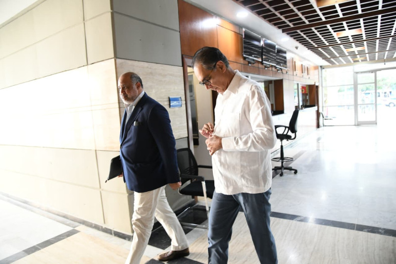 Momento en que el exdirector de Senasa, doctor Santiago Hazim, llegaba junto a su abogado, Miguel Valerio, a la Procuraduría General de la República para ser interrogado.