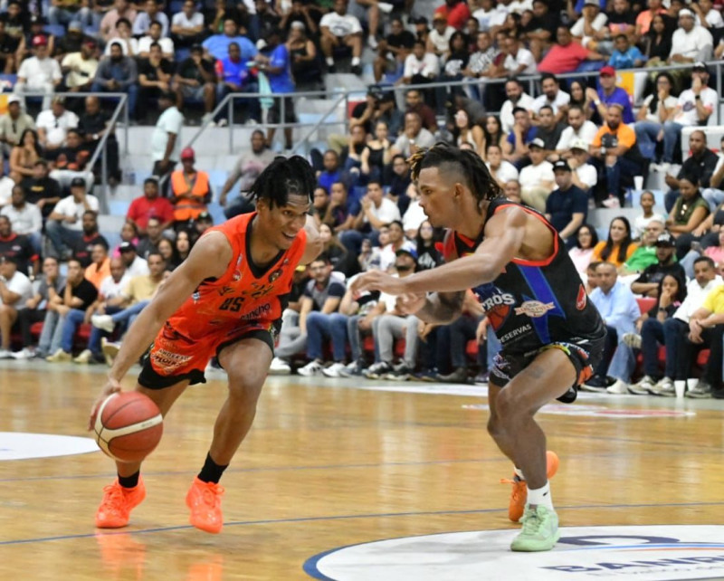 Luis Martínez, de la Villa, es defendido por Bryan Rosado, de La Matica en el quinto partido de la semifinal del torneo de baloncesto superior de La Vega.