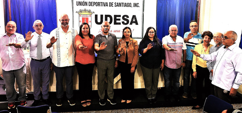 El presidente de la Comisión Electoral, William Hernández, junto a doña Julia Lora de Hieronimus y César Pichardo, juramenta a los electos de la nueva directiva de UDESA.