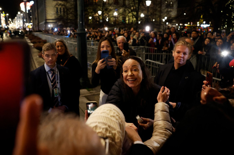 La Premio Nobel de la Paz, María Corina Machado (centro), saluda a sus simpatizantes reunidos frente al Grand Hotel de Oslo, Noruega, la madrugada del 11 de diciembre de 2025.