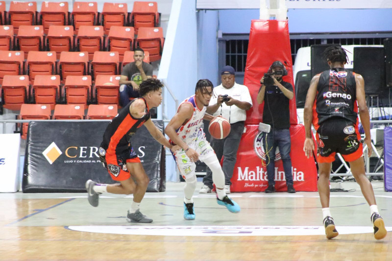 Eusebio Suero, del Dosa, es defendido por Jhon Feliz, de La Villa, durante el segundo partido de la final del torneo de baloncesto superior de La Vega.