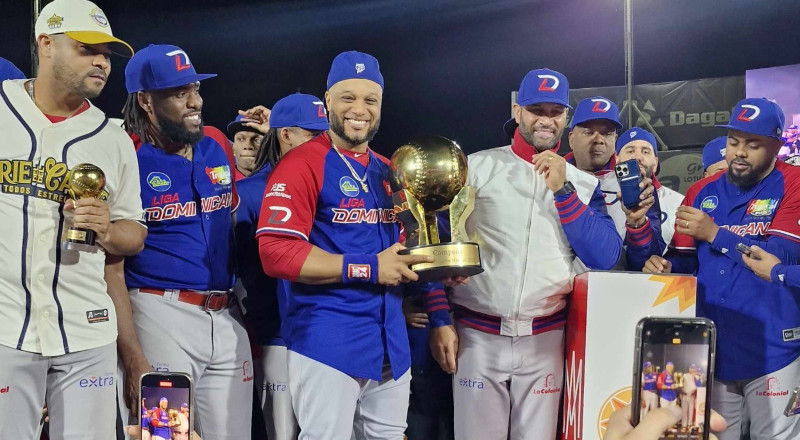 Robinson Canó sostiene el trofeo de la pasada Serie del Caribe, a su izquierda el dirigente Albert Pujols.