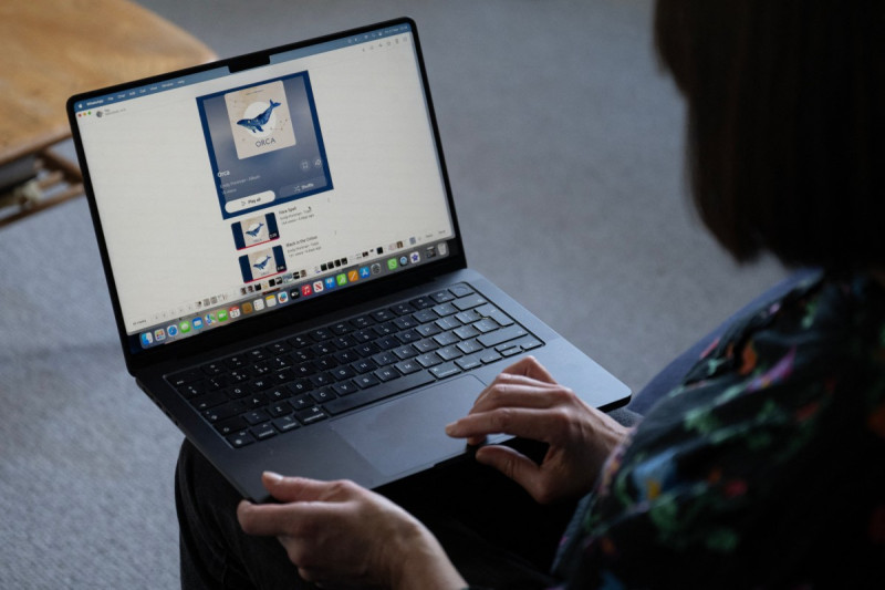 La cantante de folk Emily Portman posa para una fotografía sosteniendo una computadora portátil que muestra una captura de pantalla de un álbum falsificado que afirma falsamente haber sido creado por ella en Sheffield, en el norte de Inglaterra, el 21 de noviembre de 2025.