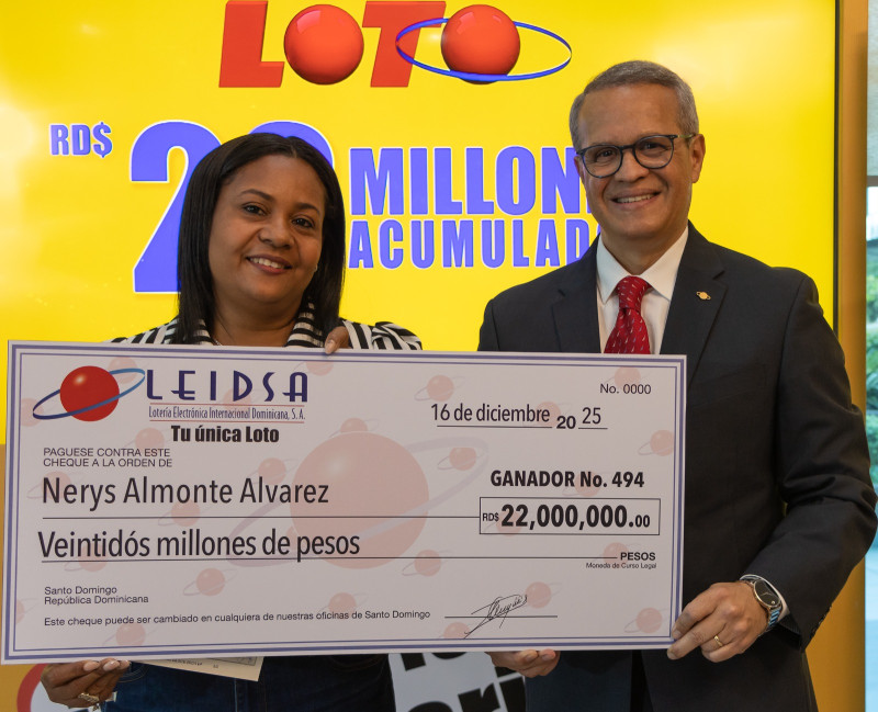 Nerys Almonte Álvarez recibe el cheque de 22 millones de pesos tras ganar el sorteo Loto del pasado sábado 22 de noviembre.