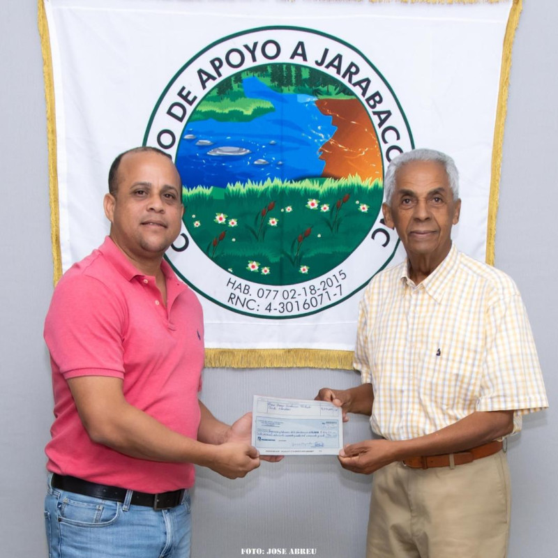 José A. Tejeda, presidente de Coaja, entrega a Lenin Herrera, el cheque para dar inicio a los trabajos de construcción.