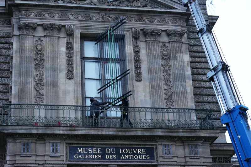Trabajadores instalan rejas de hierro en la ventana de la Galería de Apolo del Museo del Louvre, en el lado del Quai François Mitterrand, en París, el 23 de diciembre de 2025, pocas semanas después de que ladrones usaran un montacargas para entrar en el museo. Los ladrones irrumpieron en el Louvre y huyeron con joyas la mañana del 19 de octubre de 2025, tras llegar en una motocicleta con motosierras pequeñas y usar un montacargas para llegar a la sala que buscaban.