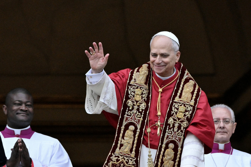 El papa León XIV saluda desde el balcón principal de la basílica de San Pedro tras pronunciar el mensaje Urbi et Orbi y la bendición a la ciudad y al mundo como parte de las celebraciones navideñas, en la plaza de San Pedro del Vaticano el 25 de diciembre de 2025.