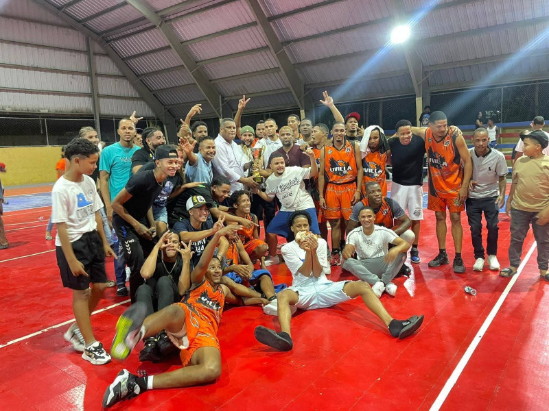 Jugadores, entrenadores, fanáticos y dirigentes de Uvilla posan con la copa de campeón.