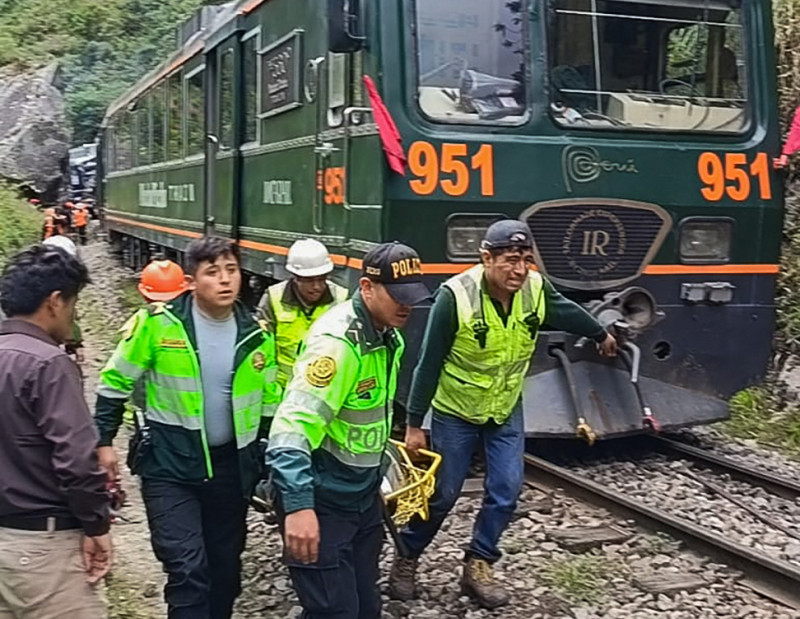 Agentes de policía transportan a un pasajero herido de uno de los dos trenes implicados en una colisión frontal que conecta Machu Picchu con Ollantaytambo en Pampacahua, Departamento de Cusco, Perú, el 30 de diciembre de 2025.