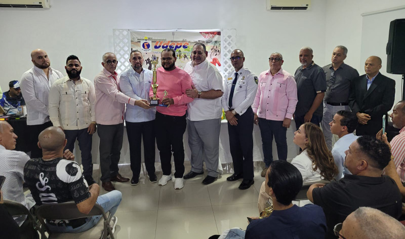 El entrenador Cristian Reyes, en representacion de Jean Carlos López, recibe el reconocimiento de ejecutivos y autoridades.