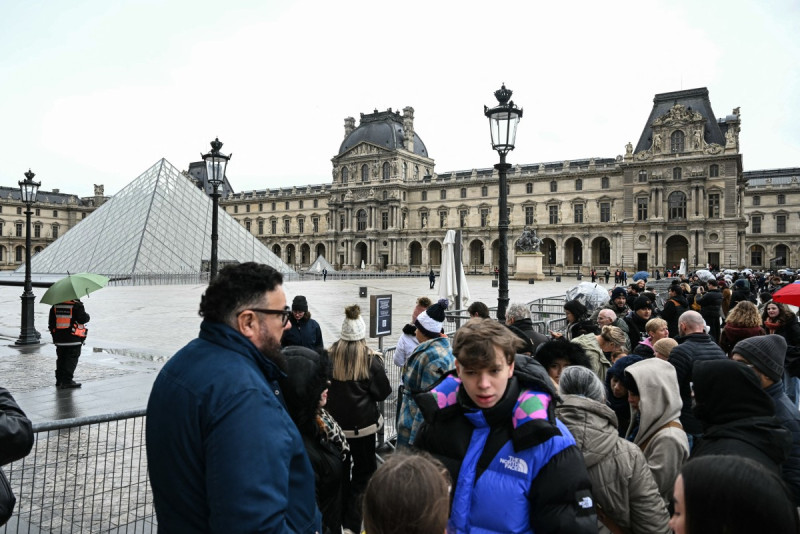 Turistas junto a las barreras que bloquean la plaza con la Pirámide del Louvre, diseñada por el arquitecto chino-estadounidense Ieoh Ming Pei, debido al cierre del Museo del Louvre debido a una huelga en París el 12 de enero de 2026.