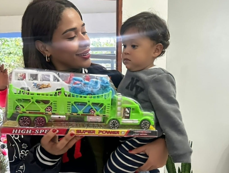 La merenguera Steffany Constanza carga uno de los niños a los que llevó alegría y esperanza en el Día de Reyes.