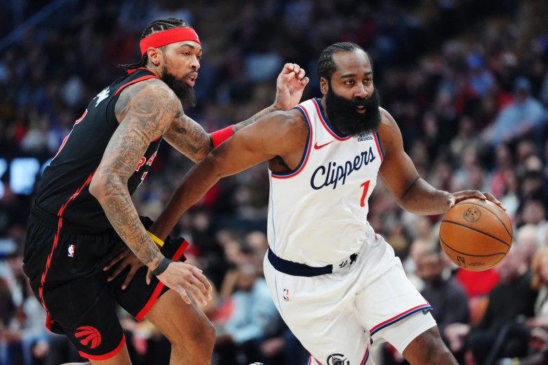 James Harden (1), de Los Angeles Clippers, supera a Brandon Ingram, de Toronto Raptors, a la izquierda, durante un partido de baloncesto de la NBA en la primera mitad en Toronto.,