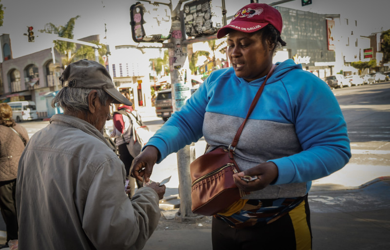 MEX2857. TIJUANA (MÉXICO), 18/01/2026.- Una migrante haitiana vende su mercancía este sábado, en la ciudad de Tijuana (México). A una década del arribo masivo de personas migrantes haitianas a la mexicana Tijuana, la comunidad que decidió establecerse en esta ciudad fronteriza continúa enfrentando barreras estructurales que dificultan su integración plena a la sociedad, en un contexto marcado por la precariedad laboral, la falta de regularización migratoria y la persistente discriminación racial. EFE/Joebeth Terríquez