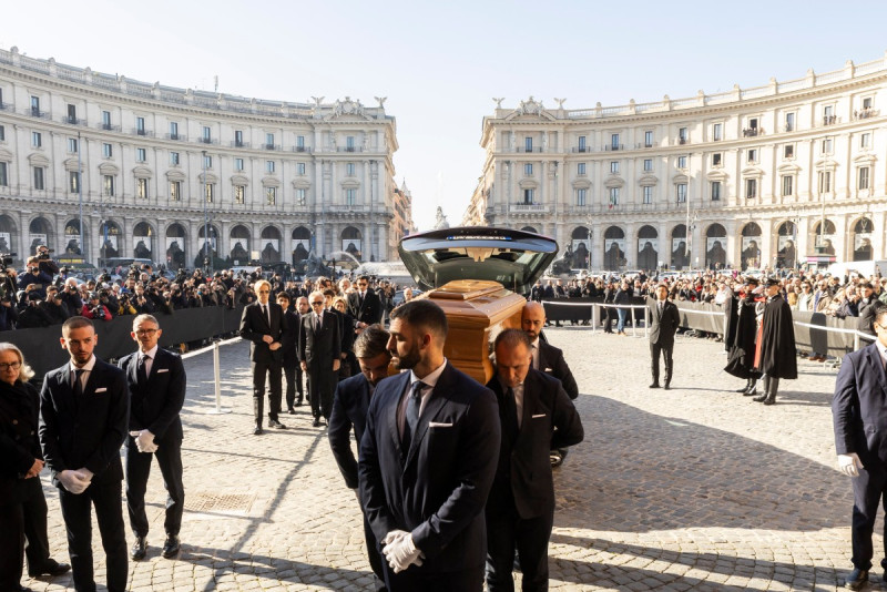 El empresario italiano Giancarlo Giammetti (centro, 2.º por la izquierda) y Vernon Bruce Hoeksema (centro-izquierda) siguen el féretro del difunto diseñador de moda italiano Valentino Gavarani a su llegada a la ceremonia fúnebre en la Basílica de Santa María de los Ángeles y de los Mártires, en Roma, el 23 de enero de 2026.