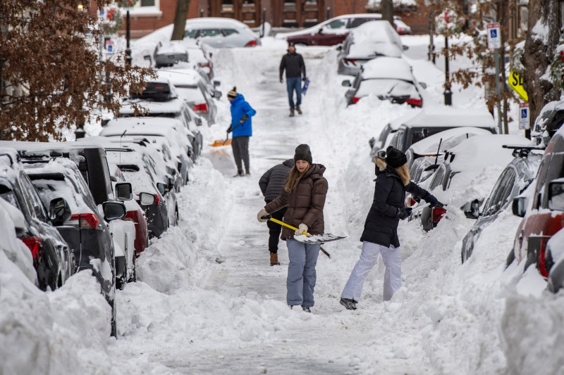 Personas palean nieve en una calle residencial del barrio de Charlestown en Boston, Massachusetts, el 26 de enero de 2026.