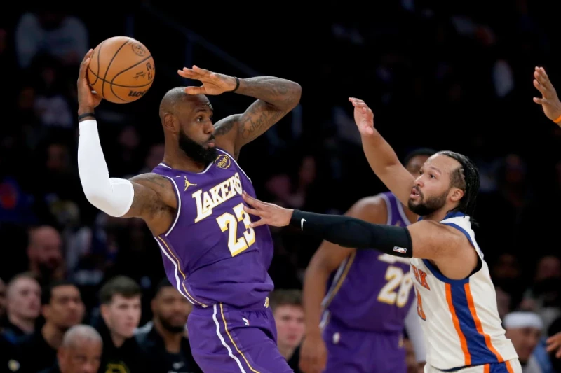LeBron James, de los Lakers, busca el pase ante la defensa de Jalen Brunson, de los Knicks, durante la primera mitad de un juego de la NBA el 1 de febrero de 2026.