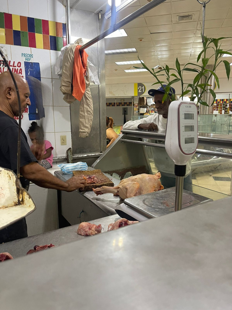 Eugenio, uno de los vendedores del mercado de Cristo Rey despachando a un cliente.