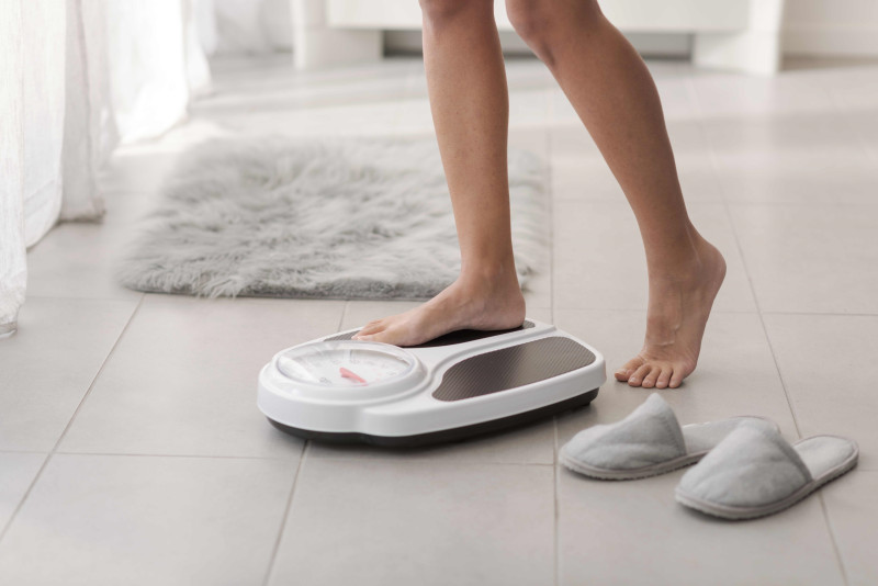 Imagen de recurso de una mujer en una báscula.