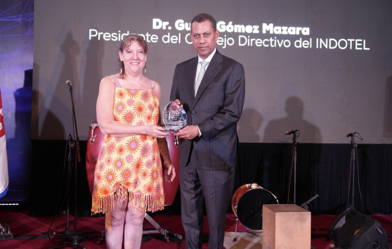 El presidente del Indotel, Guido Gómez Mazara, entregó un reconocimiento a Laura Sklar, viuda de Luis Días.