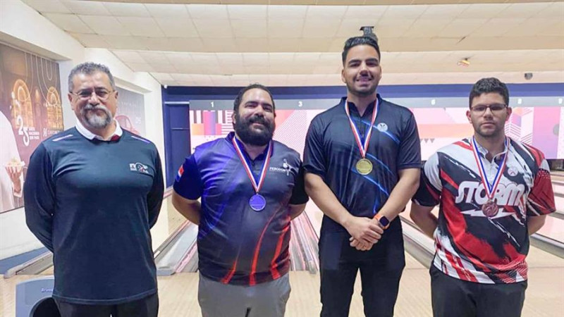 El entrenador de la selección nacional de boliche, Ernesto Avila (izq.) durante la premiación de los medallistas en la categoría élite masculina Wascar Cavallo (centro del podio), Manuel Fernández (izquierda del podio) y Leonardo Ardente.