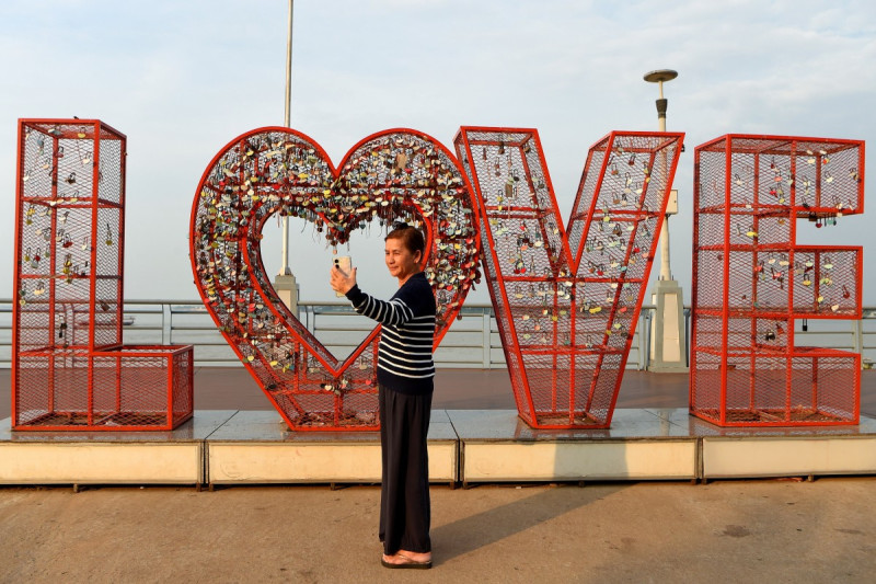 Una mujer se toma una selfie frente a una instalación que representa la palabra LOVE el Día de San Valentín en Phnom Penh el 14 de febrero de 2026.