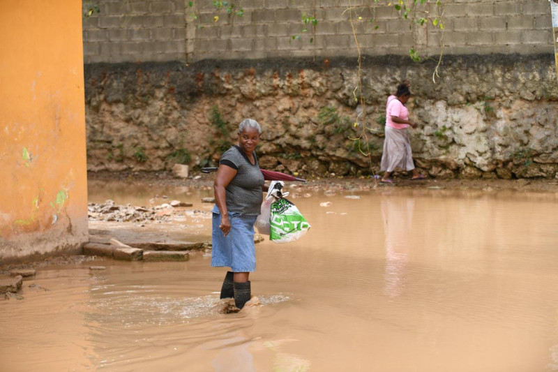 La travesía de los comunitarios tras cruzar por el agua estancada en el residencial Nancy Nadesha, en Santo Domingo Este.