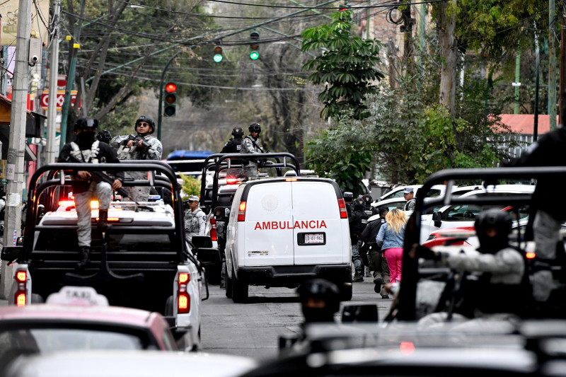 Fuerzas especiales de la Guardia Nacional Mexicana escoltan una ambulancia del servicio forense a su llegada a la sede de la Fiscalía Especializada en Delincuencia Organizada (FEMDO) en la Ciudad de México el 22 de febrero de 2026.