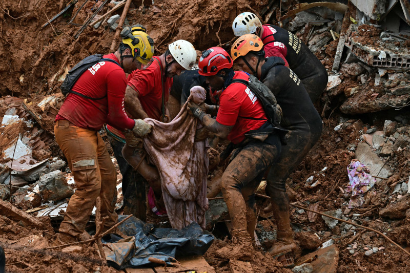 Bomberos cargan un cadáver encontrado entre los escombros después de un deslizamiento de tierra causado por fuertes lluvias en el barrio Parque Jardim Burnier en Juiz de Fora, estado de Minas Gerais, Brasil, el 24 de febrero de 2026.
