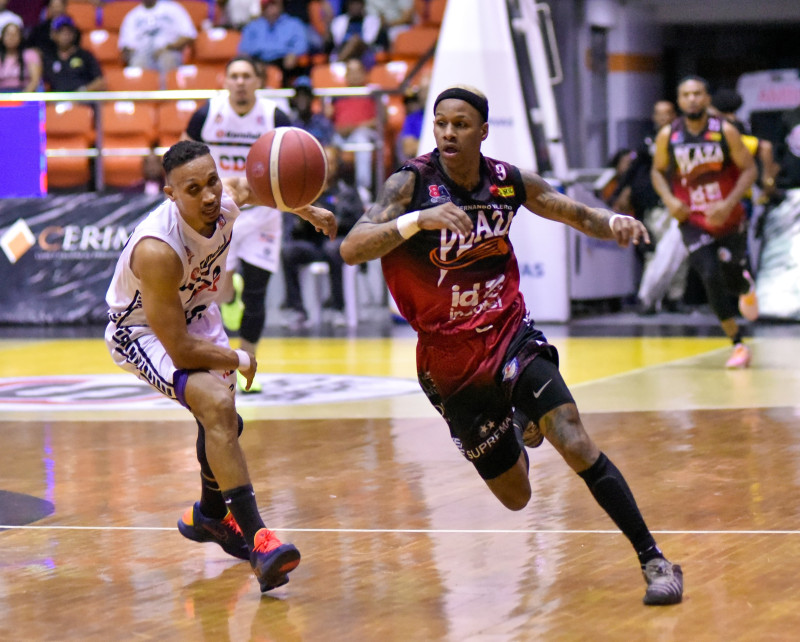 Oliver García, de Plaza Valerio, va tras un balón junto a Adris de León, del CDP, en acción del torneo de baloncesto superior de Santiago, el 24 de febrero de 2026.
