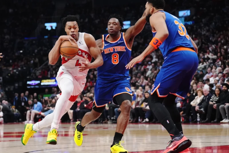 Karl-Anthony Towns, a la derecha, y OG Anunoby, al centro, de los Knicks, defienden a Scottie Barnes, de los Raptors, en el juego de la NBA, el 3 de marzo de 2026.