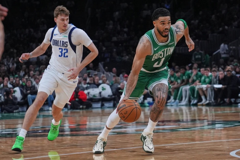 ayson Tatum (0), de los Celtics de Boston, lleva el balón frente a Cooper Flagg (32), de los Mavericks de Dallas, durante la segunda mitad del juego de baloncesto de la NBA.