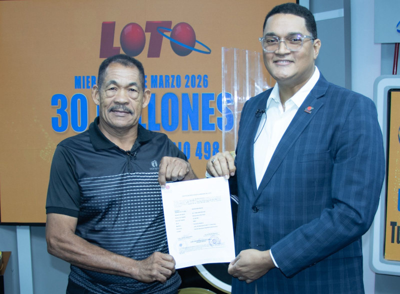 Nicolás Ramírez, a la izquierda, recibe el certificado que lo acredita como ganador de 30 millones de pesos.