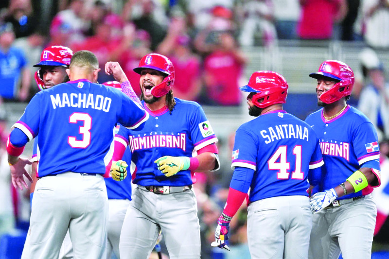 Fernando Tatis Jr. es recibido por Manny Machado y Carlos Santana luego de conectar jonrón con las bases llenas contra Países Bajos.