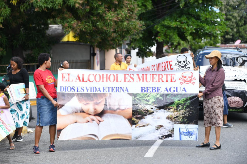Integrantes de la caminata de concienciación exhiben una pancarta con la frase: “El alcohol es muerte, Dios es vida eterna, bebe agua”.