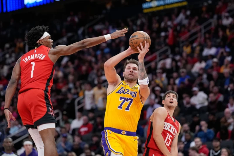 Luka Doncic, de los Lakers, lanza mientras Amen Thompson, de los Rockets, defiende durante la primera mitad del juego de la NBA, el 16 de marzo de 2026, en Houston.