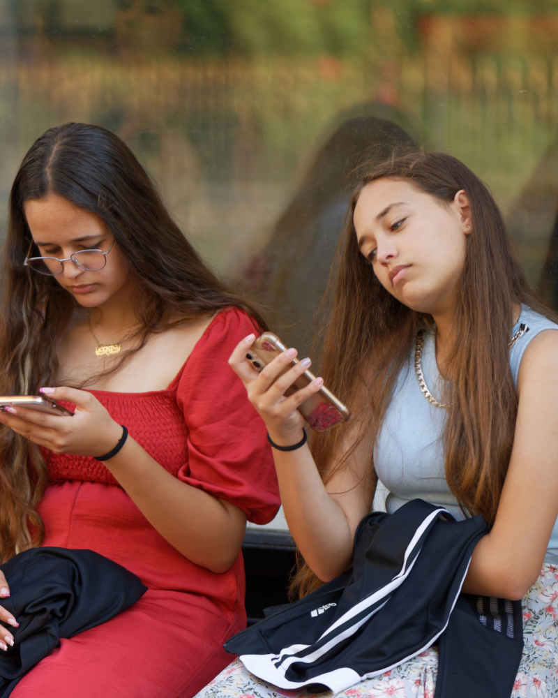 Dos chicas usando su celular.