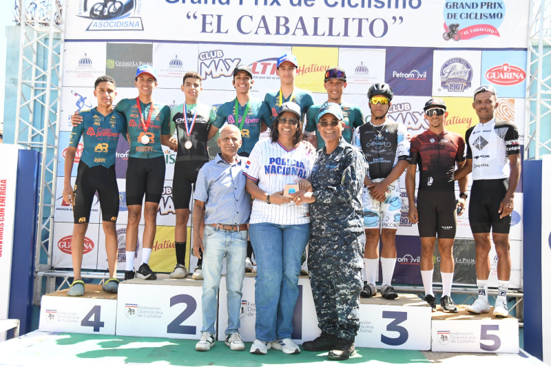Emilio Valdez (El Caballito), el general Jacobo Mateo Moquete y su esposa Allyson Espinal premian a los campeones de la categoría Open del Grand Prix de Ciclismo El Caballito.