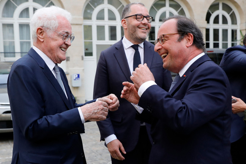 El ex primer ministro francés Lionel Jospin (izquierda) y el expresidente francés François Hollande (derecha) conversan y reaccionan durante una reunión para celebrar el fin de la sesión del grupo de senadores antes de las vacaciones de verano, en la Sede del Senado,